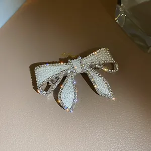 Vue détaillée de la barrette nœud ornée de perles et de strass brillants sur cuir