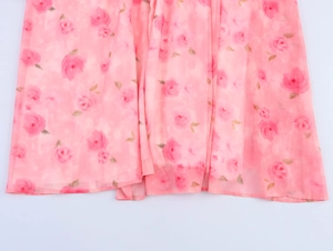 Dettaglio del tessuto in chiffon floreale rosa con drappeggio morbido per abito estivo