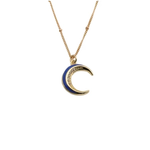 Dettaglio del ciondolo a luna dorata con smalto blu e cristalli su una catena a sfere