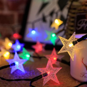 Macro view of glowing colorful star-shaped LED fairy lights for room decoration