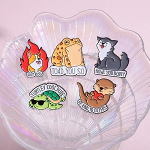 Set of five cute cartoon animal enamel pins featuring clever puns in a glass shell tray