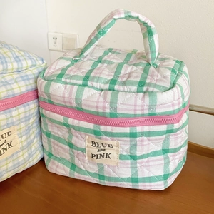 Detail of quilted cotton makeup bag with green and pink checks and blue and pink lettering
