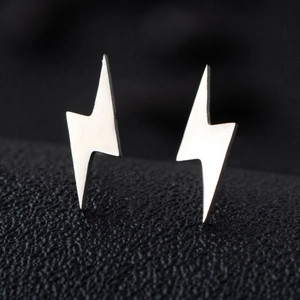 Macro view of silver lightning bolt stud earrings with polished minimalist finish