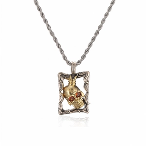 Totenkopf-Anhänger mit goldener Krone und roten Steinen an einer Silberkette