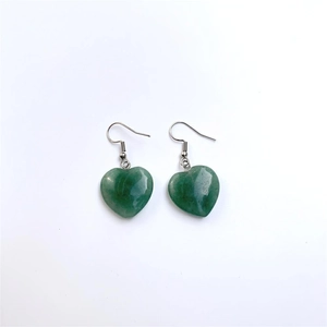 Macro detail of dark green heart-shaped stone pendant with silver hook earrings