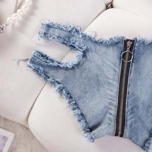 Detailansicht der Jeans-Shorts mit Metallring-Reißverschluss und ausgefransten Fransenkanten