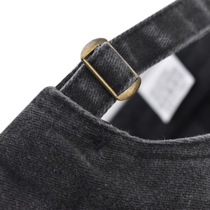 Detail of adjustable brass buckle and dark gray washed cotton fabric on baseball cap