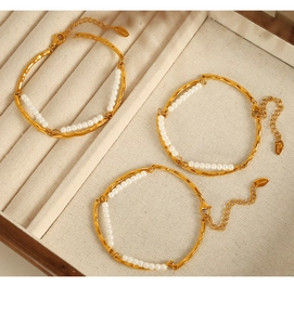 Detail of 18K gold-plated double-layer pearl bracelets in a beige jewelry organizer