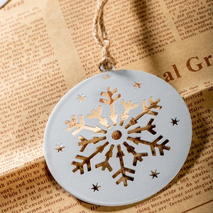 White metal snowflake ornament with rustic twine on vintage newspaper background