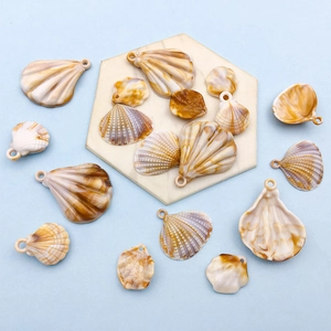 Dettaglio di ciondoli a conchiglia in acrilico con texture naturali su marmo