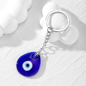 Blue glass evil eye keychain with teardrop charm and silver metal ring on white background