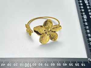Dettaglio macro del bracciale rigido a fiori in oro 18K con petali testurizzati e scala graduata