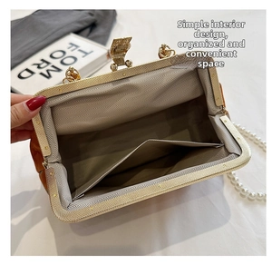 Macro view of caramel suede handbag interior with vintage metal clasp and pearl chain