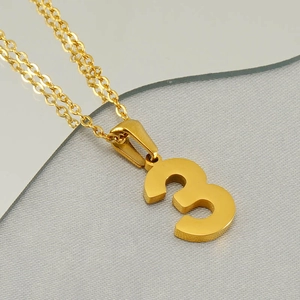 Macro shot of gold stainless steel number 3 pendant necklace with o-chain detail
