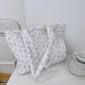 Détail macro du sac fourre-tout en coton matelassé avec motif floral et étiquette française