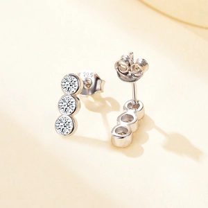 Macro shot of S925 sterling silver three-stone zircon earrings with visible hallmark