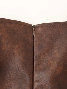 Gros plan sur la fermeture éclair invisible d'une veste vintage en similicuir marron