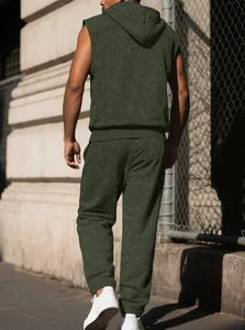 Outdoor back view of men's sleeveless olive green hoodie and pants with textured knit finish