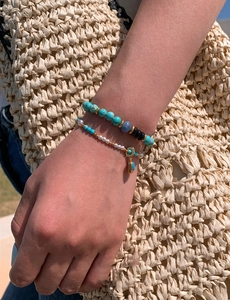 Close-up of turquoise and blue bead bracelets on wrist for a summer resort look