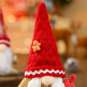 Macro shot of Christmas gnome with red knitted hat, gingerbread man, and white beard decor