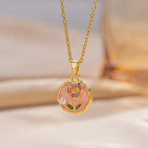 Golden necklace featuring a pink enamel flower pendant with a delicate pearl accent