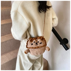 Detail of a handmade khaki crochet lion bag with 3D mane and woven shoulder strap