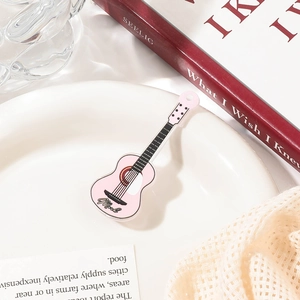 Macro detail of pink acrylic guitar hair clip featuring fine strings and texture details