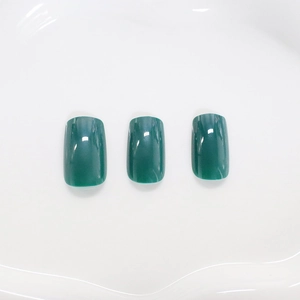 Glossy emerald green translucent square fake nails shown on white background
