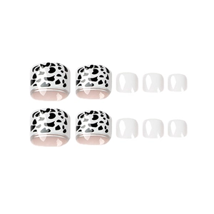 Glossy cow print and translucent white press-on toenails set on a white background