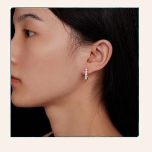 Close-up of S925 sterling silver U-shaped hoop earrings with pave moissanite on model