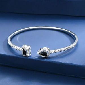 Silver cuff bracelet with pear and emerald cut black stones and micro-pave crystals