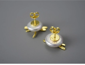 Detailed close-up of S925 sterling silver dragonfly stud earring with pearl and gold plating