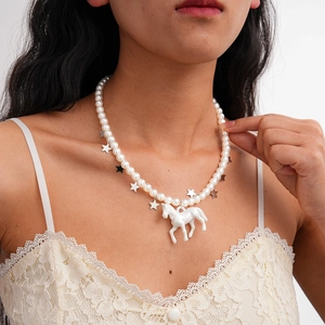 Détail d'un collier de perles avec étoiles argentées et pendentif cheval sur mannequin