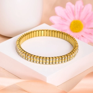 Close-up of luxury gold elastic bracelet with two rows of sparkling rhinestones