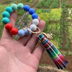 Close-up of colorful silicone bead bracelet keychain with gold clasp and leather tassel