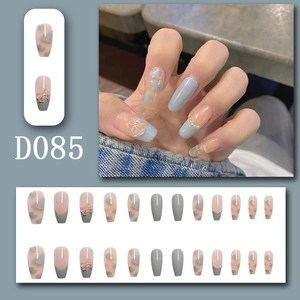 Detailed view of coffin-shaped press-on nails with blue bows and heart prints
