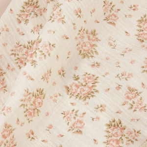 Detailed macro view of soft breathable double gauze cotton fabric with pink floral print