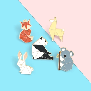 Detail of five geometric animal enamel pins including fox and panda on pastel background
