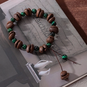 Detail view of coffee bean beads and green tiger eye stone beads on the bracelet