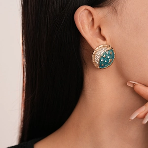 Detail of vintage star and moon enamel stud earrings with rhinestones worn by a model