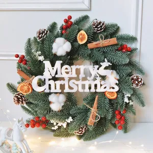 Christmas wreath with pine needles, red berries, cotton and Merry Christmas sign