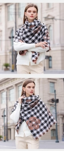 Detailed shot of black and white plaid scarf featuring brown camellia floral patterns