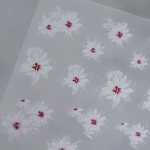 Adhesive nail art stickers featuring ultra-thin white daisy patterns with red centers