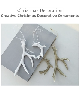 Detail of white matte and gold glitter resin reindeer antler ornaments for Christmas trees