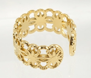 Detailed close-up of golden stainless steel ring with hollow flower pattern and open band
