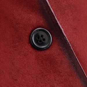 Close-up of burgundy long sleeve jacket featuring suede texture and black button detail