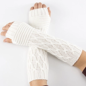 Close-up of white cable-knit fingerless gloves showing texture and ribbed cuffs