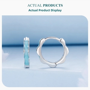 Detail of s925 silver hoop earrings featuring blue floral wave enamel patterns