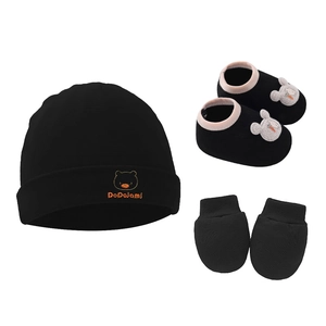 Close-up of black knit cotton baby set with embroidered bear hat and bunny shoes