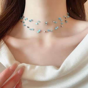 Close-up of double-layer necklace with blue cat-eye stone cubes on invisible chain